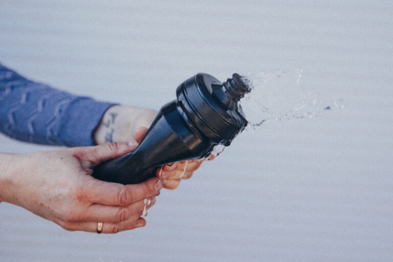 Das Bild zeigt eine Trinkflasche, aus der das Wasser sprudelt